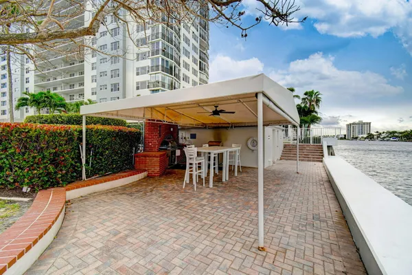a view of a patio with a table and chairs under an umbrella