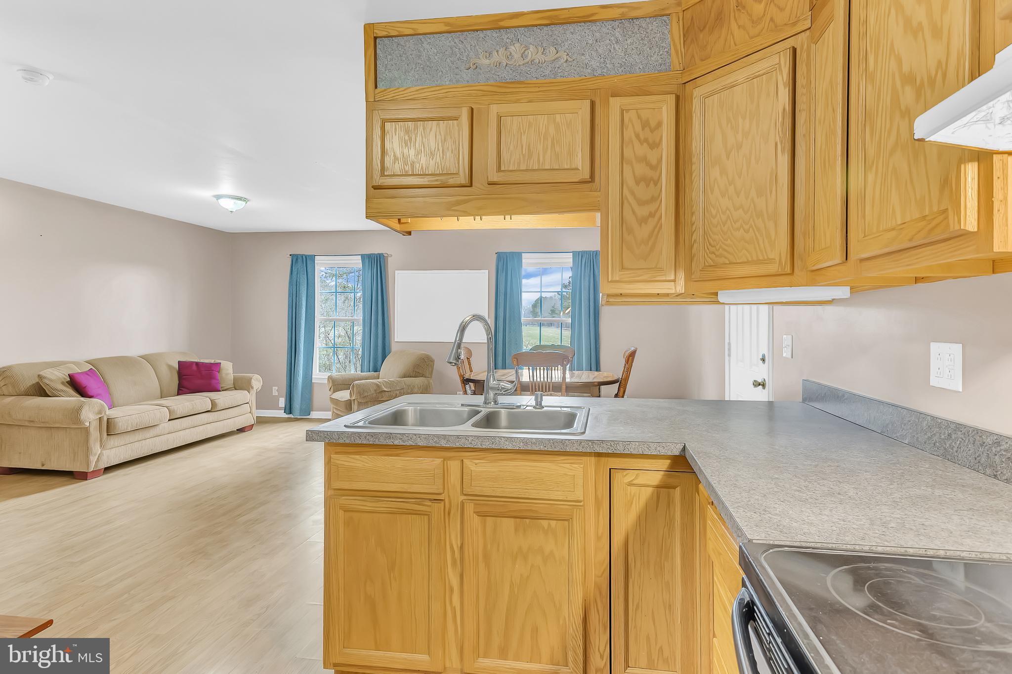 29827 Polks Road Princess Anne, MD 21853 - Photo 13 of 41 a kitchen with kitchen island granite countertop a sink and a stove top oven