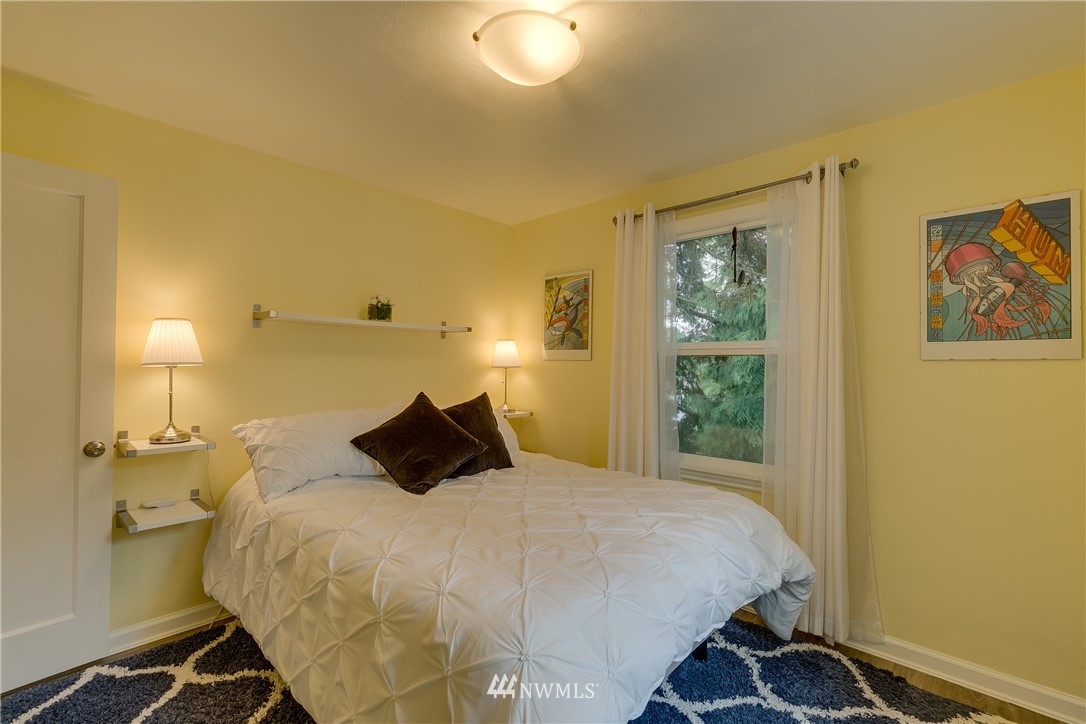 6745 18th Avenue Southwest Seattle, WA 98106 - Photo 11 of 24 a bedroom with a bed and wooden floor