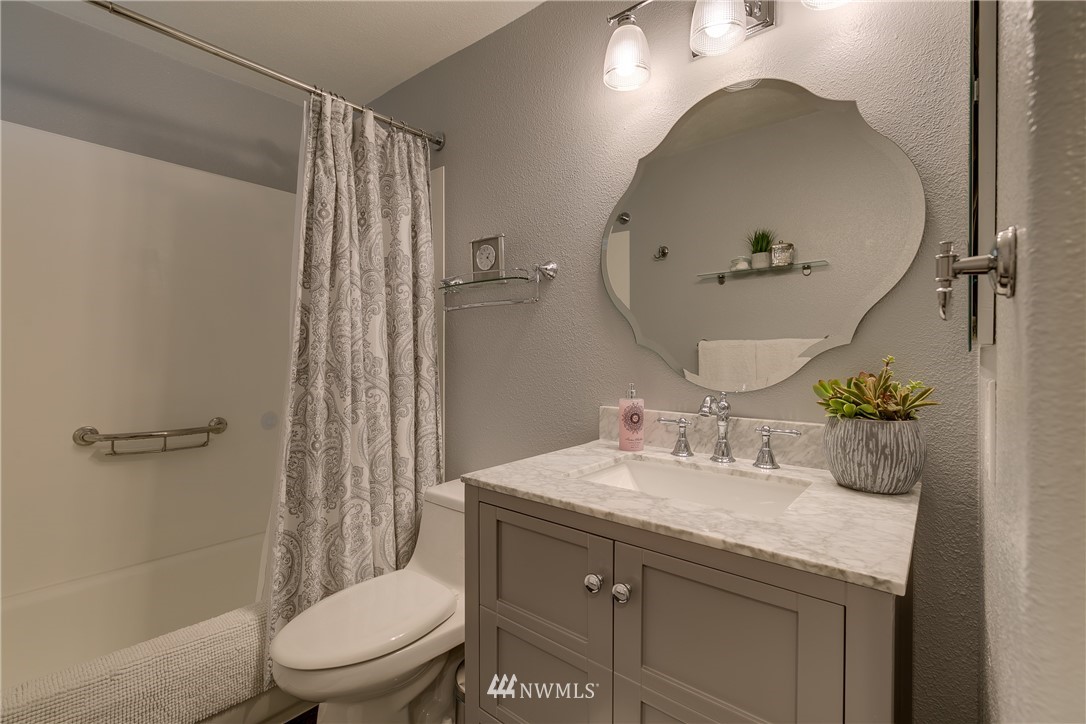 6745 18th Avenue Southwest Seattle, WA 98106 - Photo 13 of 24 a bathroom with a granite countertop sink toilet and shower