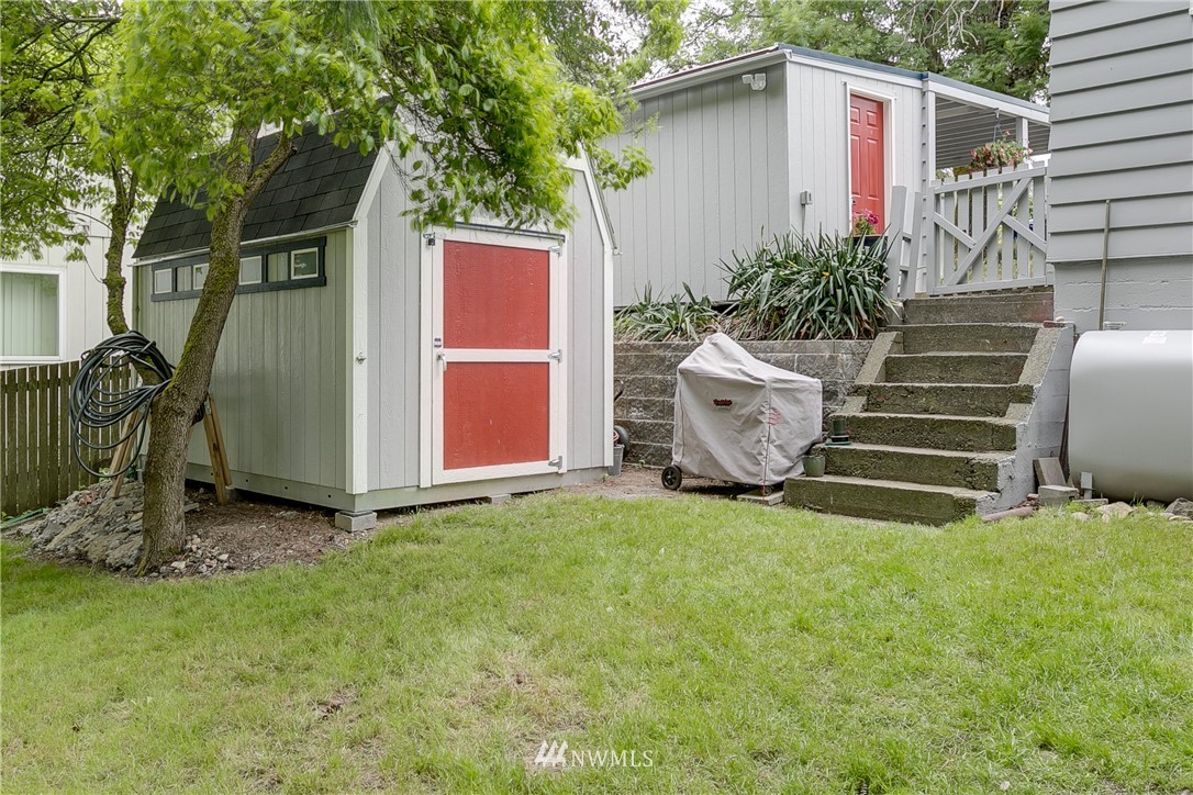 6745 18th Avenue Southwest Seattle, WA 98106 - Photo 21 of 24 a view of a backyard with plants and a large tree