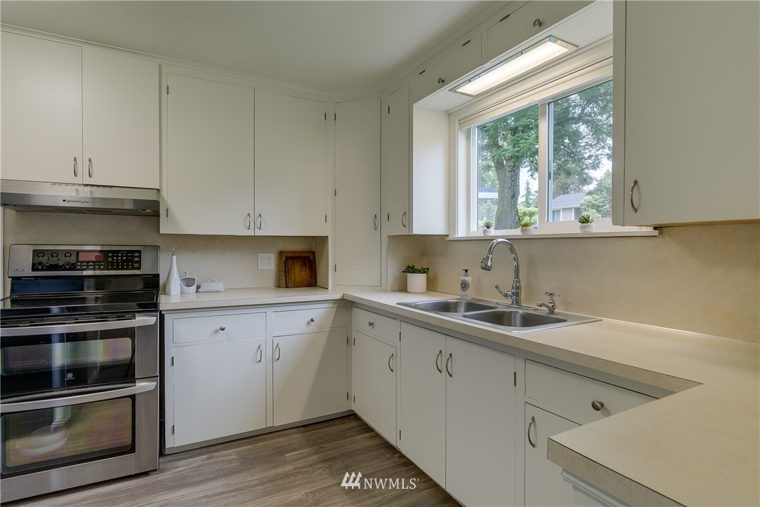 6745 18th Avenue Southwest Seattle, WA 98106 - Photo 8 of 24 a kitchen with a sink stove and cabinets