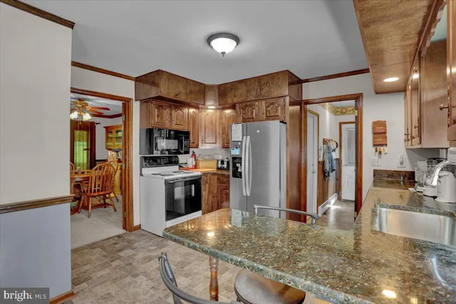 a kitchen with stainless steel appliances granite countertop a stove refrigerator sink and cabinets