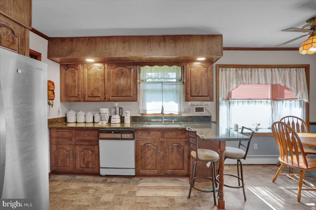 90 Preston Road Wernersville, PA 19565 - Photo 24 of 45 a kitchen with granite countertop a table chairs stove microwave and cabinets