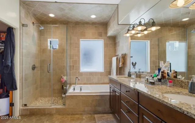 a bathroom with a granite countertop sink a large mirror and a shower