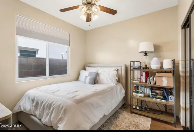 a bedroom with a bed chandelier and a window