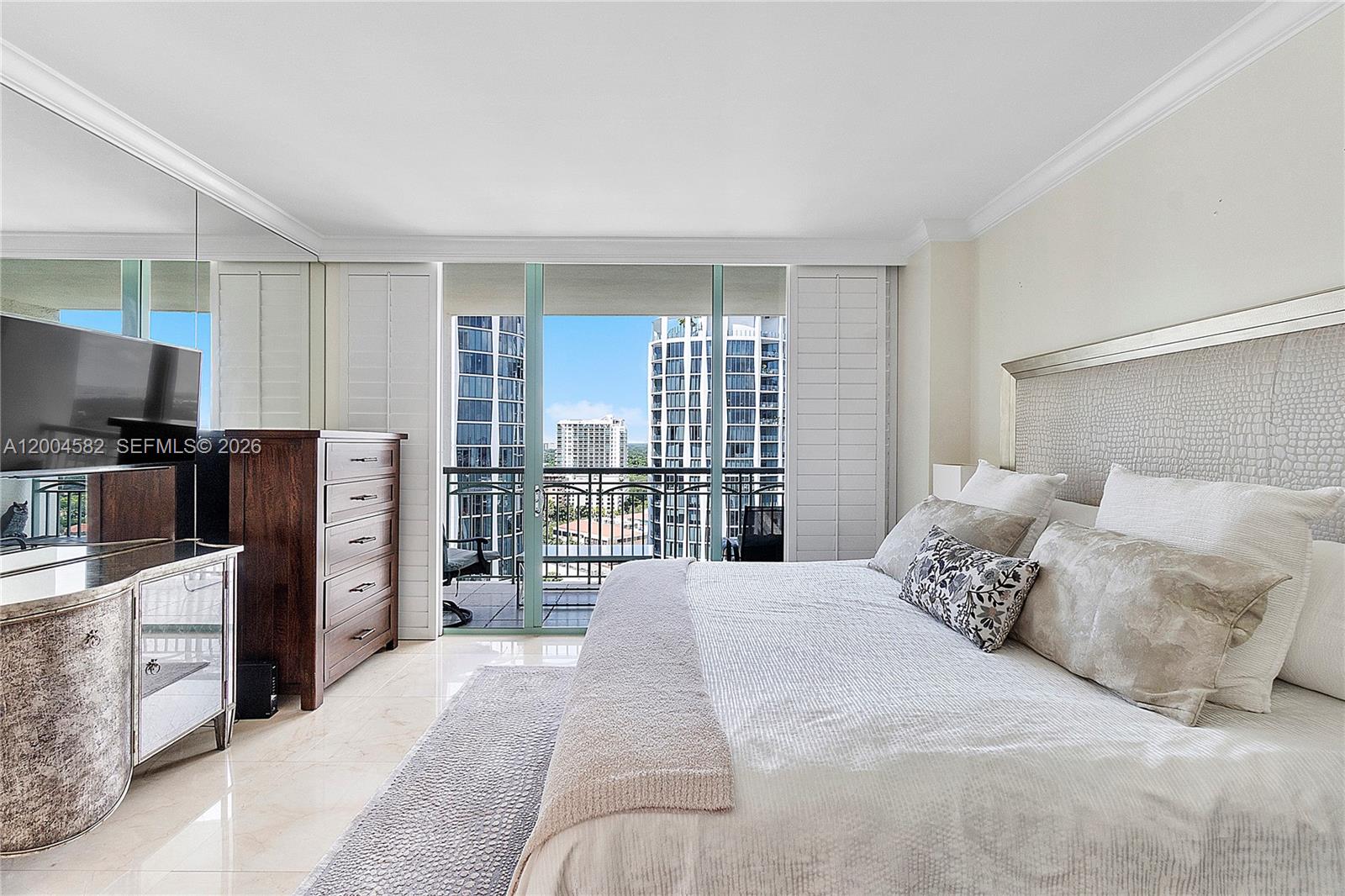 3350 Southwest 27th Avenue, Unit 1803 Miami, FL 33133 - Photo 12 of 22 a bedroom with a large bed and a flat tv screen