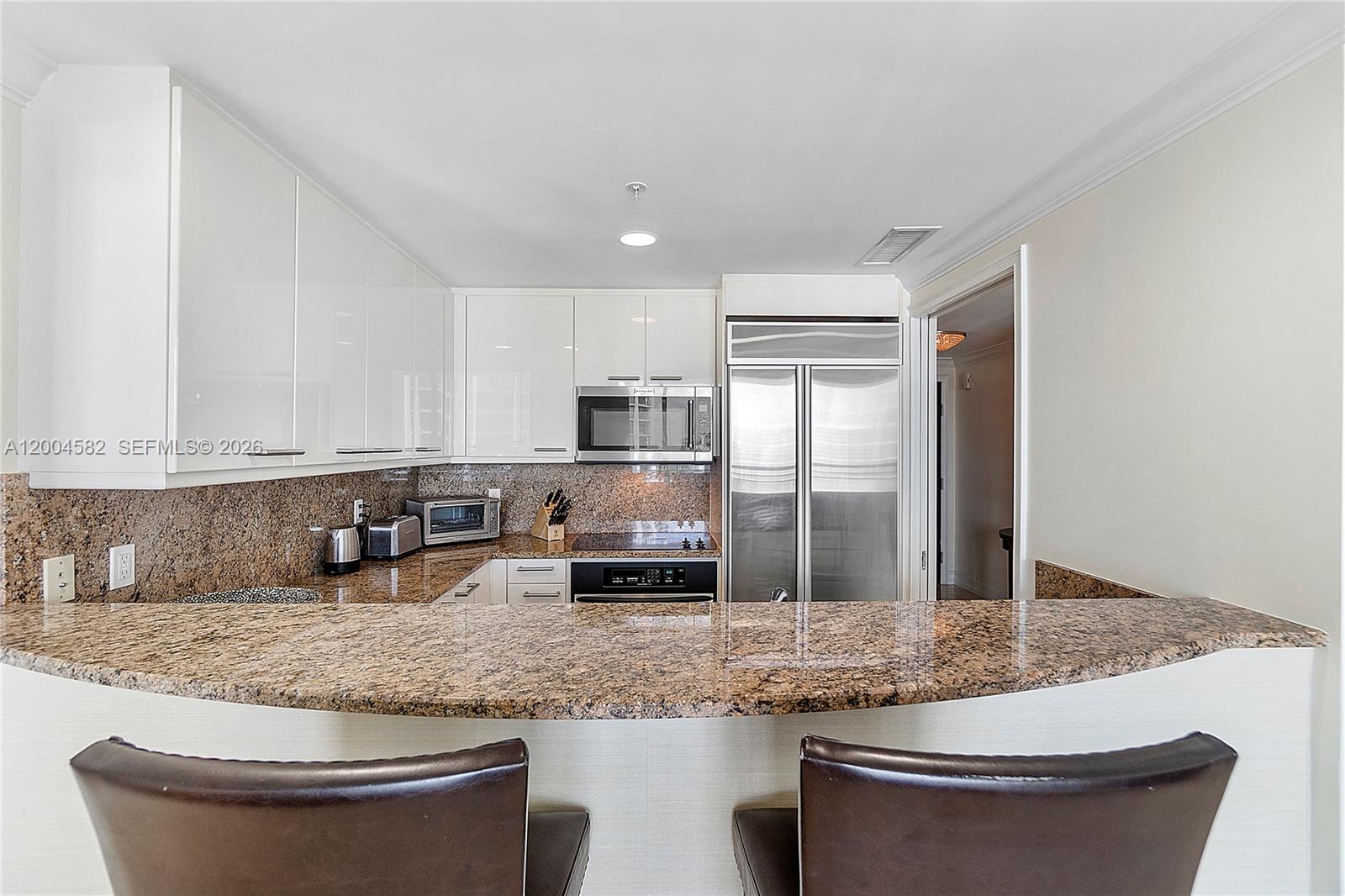 3350 Southwest 27th Avenue, Unit 1803 Miami, FL 33133 - Photo 9 of 22 a kitchen with granite countertop a sink and a stove top oven