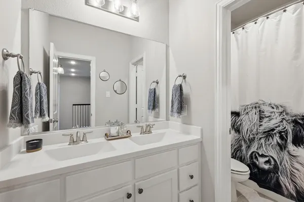 a bathroom with a double vanity sink and a mirror