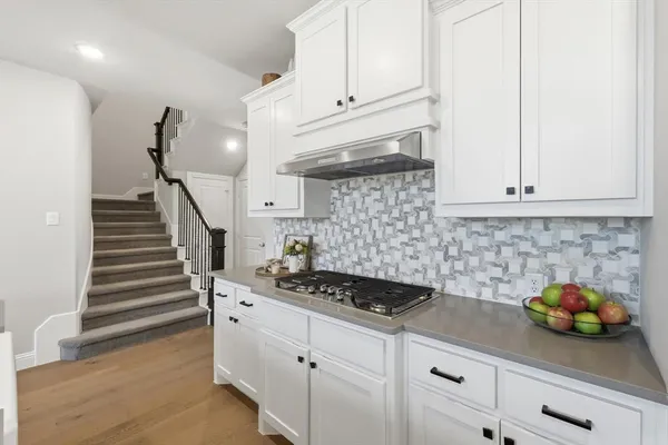 a kitchen with white cabinets and appliances