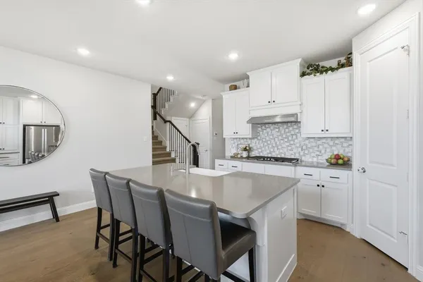 a kitchen with a dining table chairs sink and cabinets