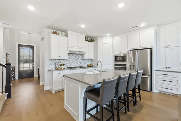 a kitchen with stainless steel appliances kitchen island granite countertop a refrigerator and a stove top oven