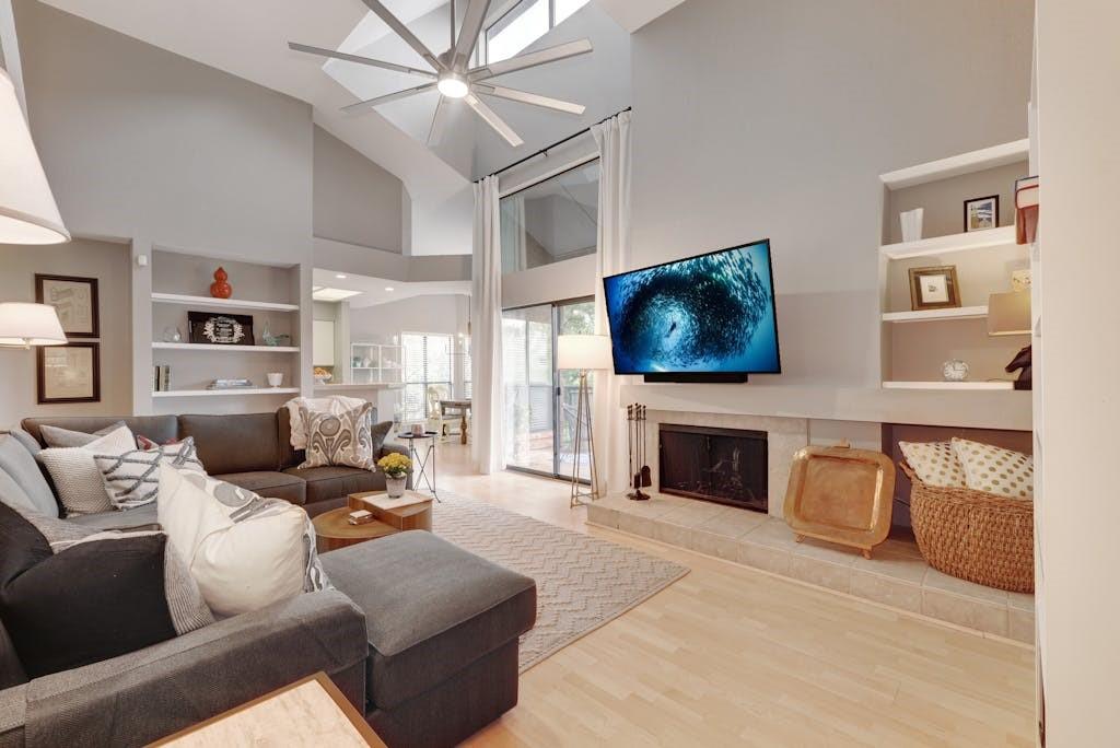 Enter to the Living Room with vaulted ceilings and fireplace and modern fan