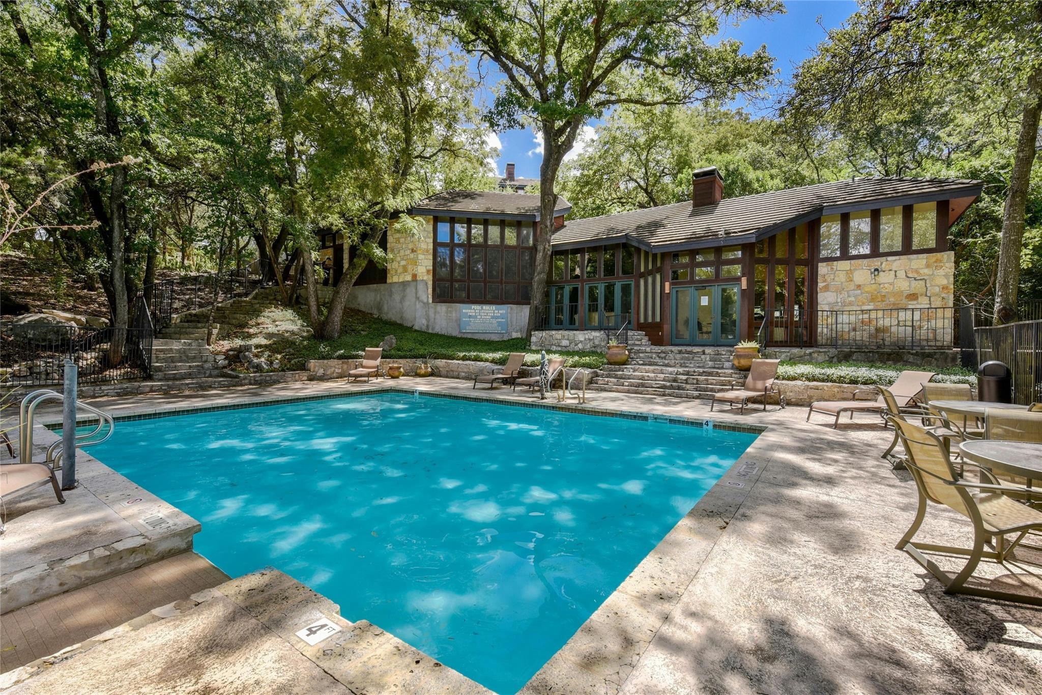 4711 Spicewood Springs Road, Unit 1201 Austin, TX 78759 - Photo 32 of 35 Clubhouse and community pool surrounded by mature trees and shaded seating