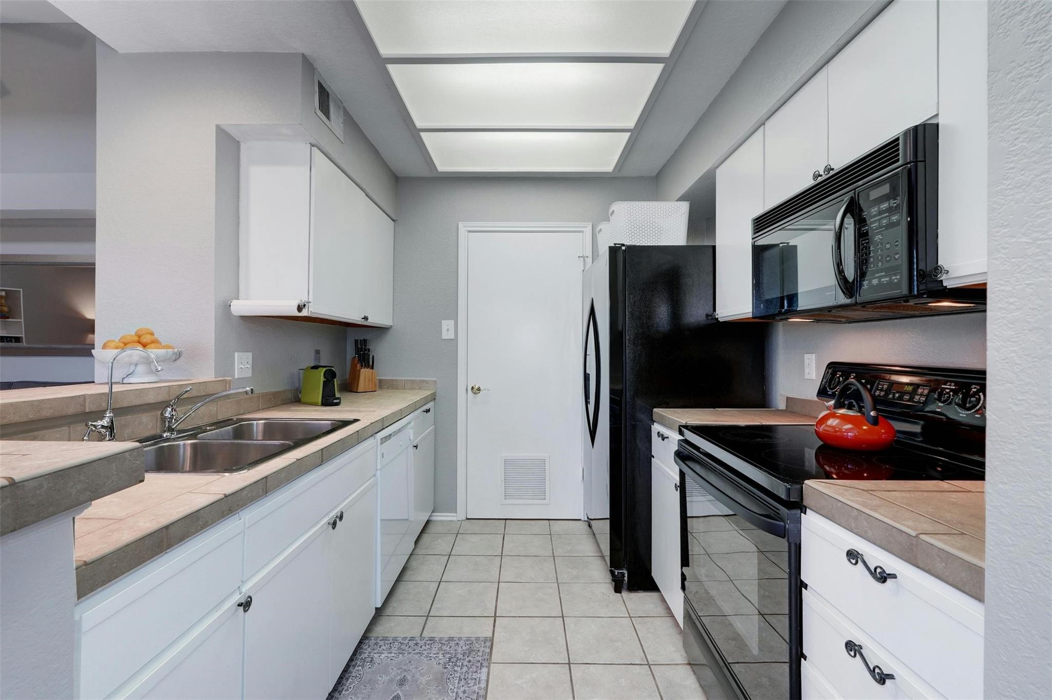 4711 Spicewood Springs Road, Unit 1201 Austin, TX 78759 - Photo 10 of 35 Kitchen with generous cabinetry and convenient adjacent laundry room