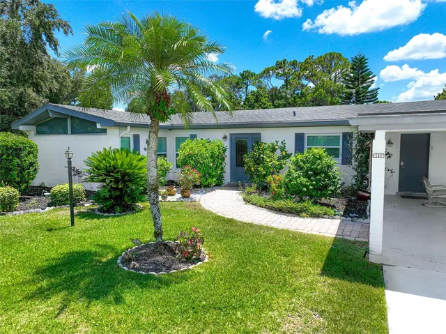 a front view of a house with a yard and potted plants