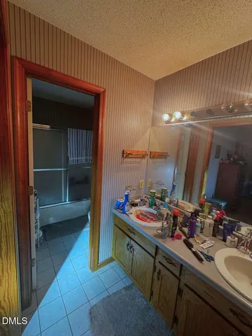 a bathroom with sink a mirror and shower