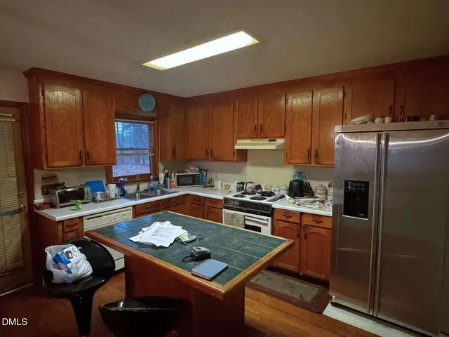 a kitchen with granite countertop stainless steel appliances and wooden cabinets