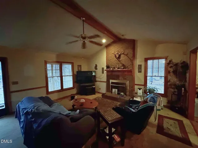 a living room with furniture a fireplace and a flat screen tv