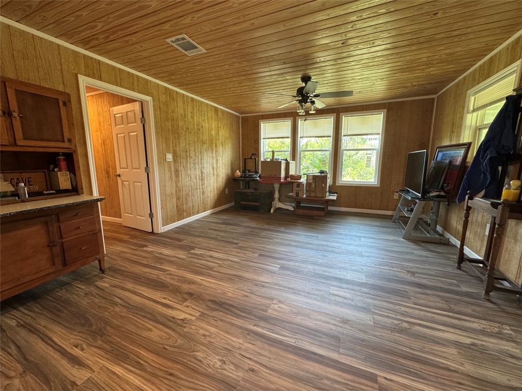 8060 County Road 210 Bertram, TX 78605 - Photo 32 of 40 Living area featuring wooden ceiling, dark wood-style floors, wood walls, ornamental molding, and a ceiling fan