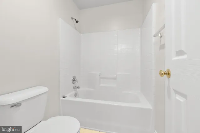 a white toilet sitting next to a bath tub