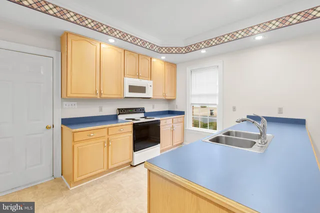 a kitchen with granite countertop cabinets stainless steel appliances a sink and a window