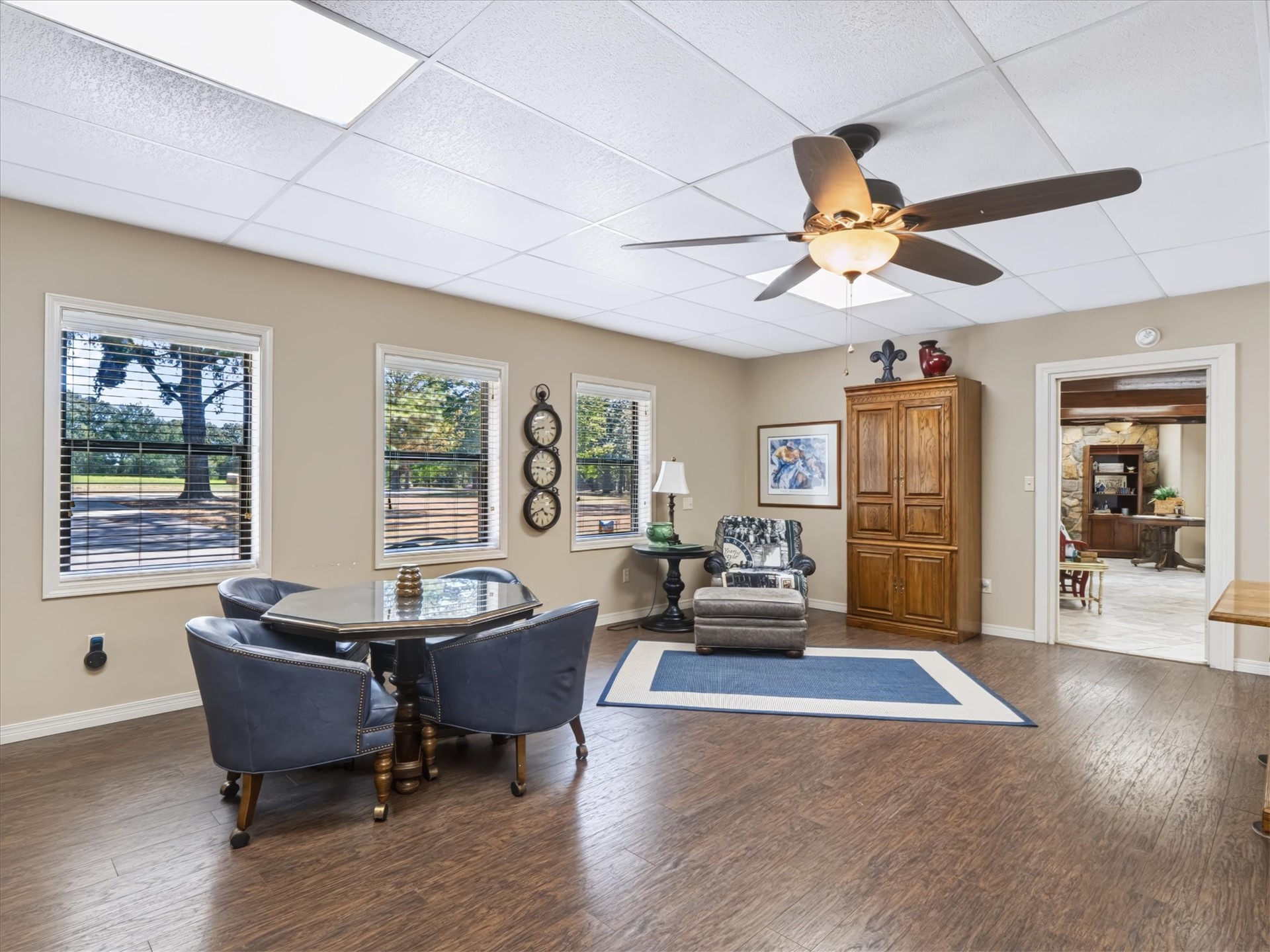 1133 West Chicken Fight Road Atoka, OK 74525 - Photo 37 of 49 Recessed ceiling lighting, wood-finish flooring, ceiling fan with integrated lighting, multiple windows, and a doorway to another room