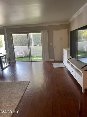 a view of an empty room with wooden floor fireplace and a window