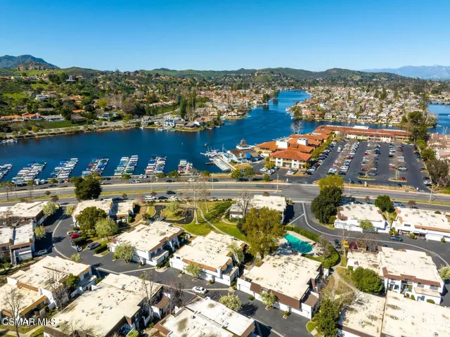 a view of a swimming pool with a yard and large trees