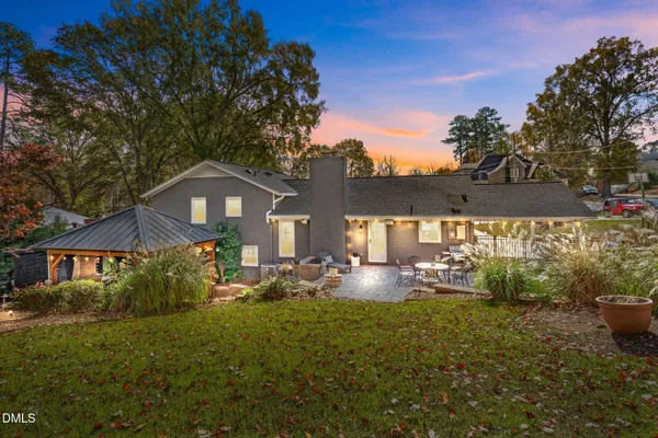 a kitchen with kitchen island a refrigerator a stove a dining table and chairs with wooden floor