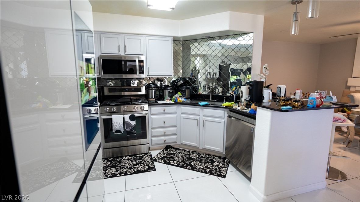 6429 Winding Ridge Las Vegas, NV 89156 - Photo 7 of 16 A well-appointed kitchen features stainless steel appliances and glossy tile flooring.