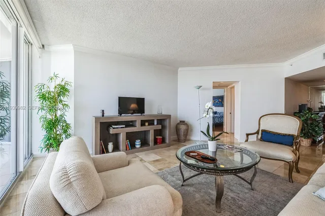 a living room with furniture a flat screen tv and a table