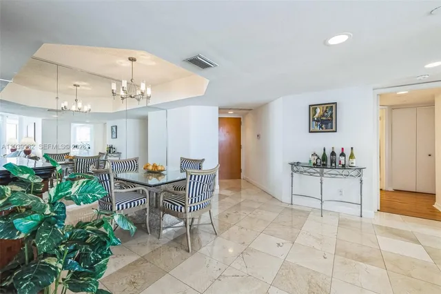 a view of a dining room and livingroom with furniture a rug a potted plant and a painting