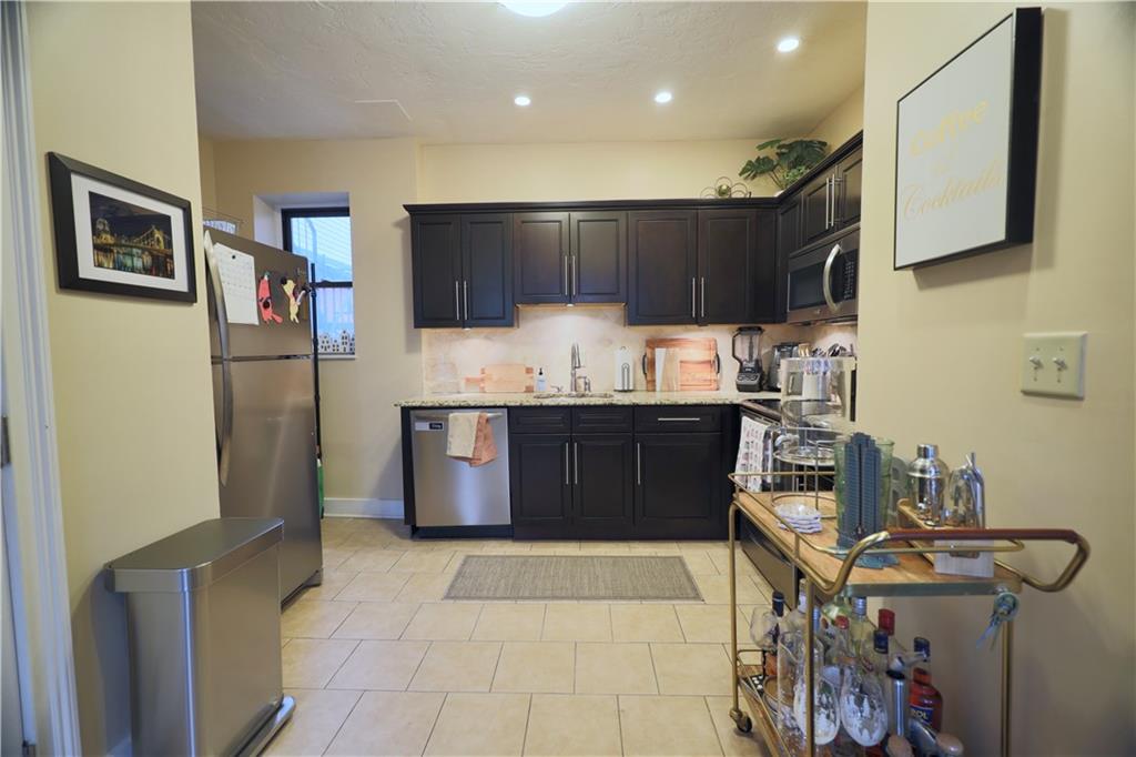 515 Lockhart Street, Unit 3 Pittsburgh, PA 15212 - Photo 7 of 27 a kitchen with stainless steel appliances granite countertop a refrigerator and a sink