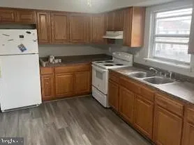 a kitchen with a sink a stove a refrigerator and cabinets