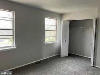 an empty room with windows and closet