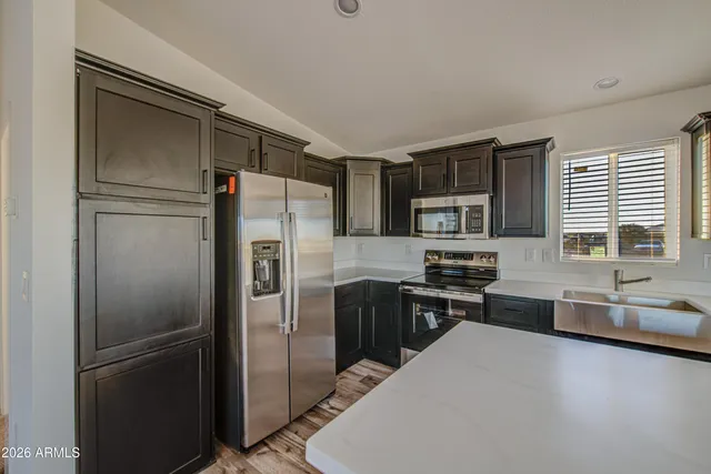 a kitchen with stainless steel appliances granite countertop a refrigerator and a sink