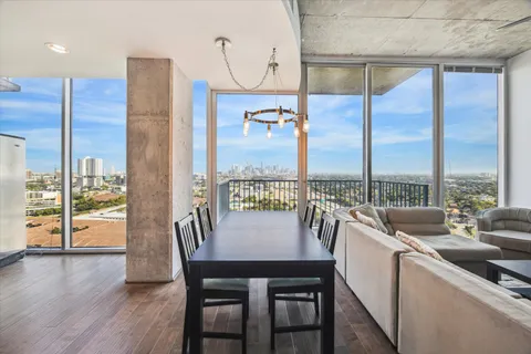 a dining room with furniture water view and a floor to ceiling window