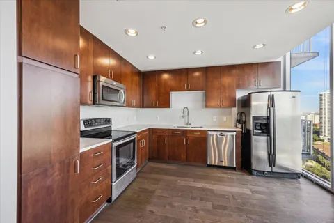 a kitchen with stainless steel appliances granite countertop a refrigerator a stove a sink and a microwave