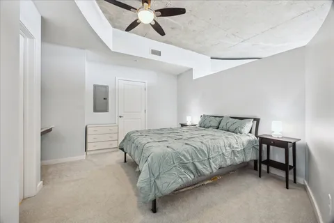 a spacious bedroom with a bed and a chandelier