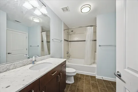 a bathroom with a granite countertop sink a toilet and shower