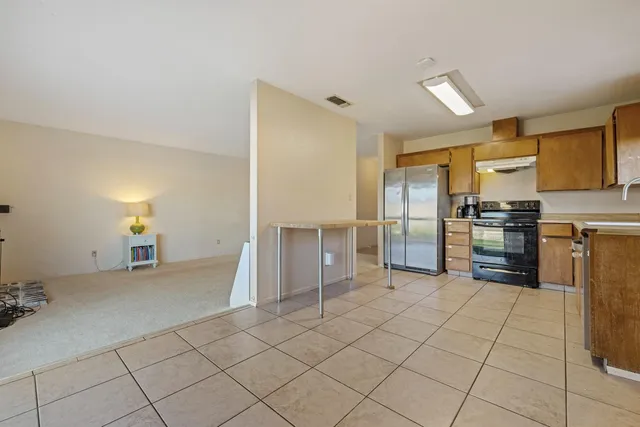 a kitchen with granite countertop a refrigerator and a stove top oven