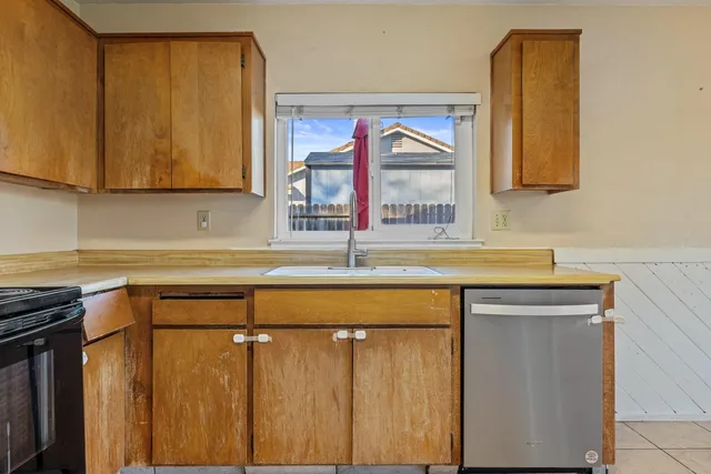 a kitchen with a sink cabinets and a window