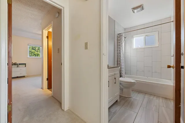 a bathroom with a granite countertop sink toilet mirror and bathtub