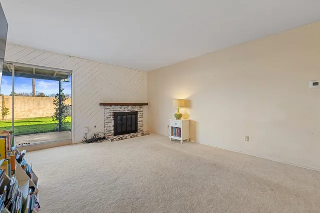 a view of a livingroom with a fireplace and a window