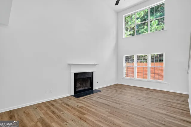 a view of empty room with wooden floor and fireplace