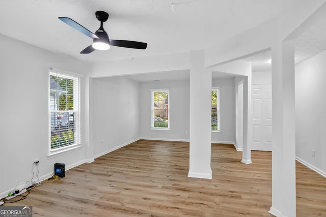 a view of an empty room with wooden floor and cabinet