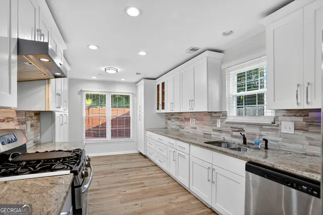 a kitchen with granite countertop white cabinets and white appliances