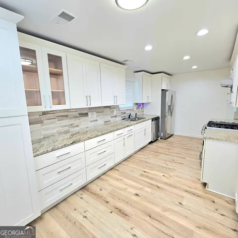 a kitchen with stainless steel appliances granite countertop a stove top oven a sink and dishwasher