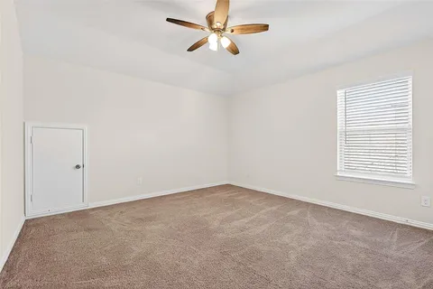 an empty room with a window and a fan
